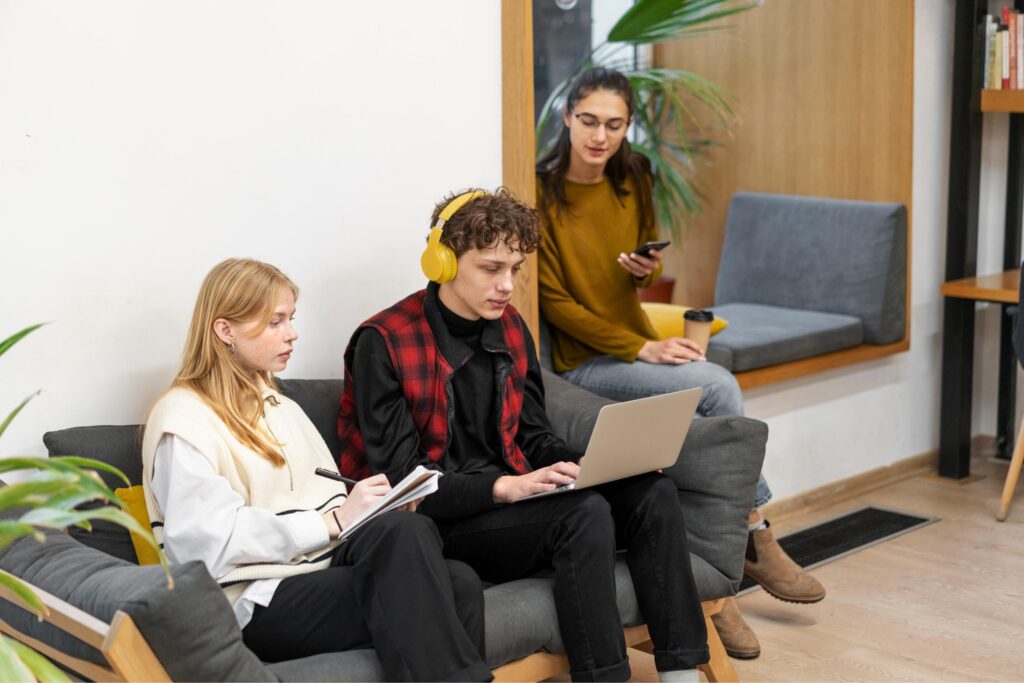 Students on a coach using a laptop